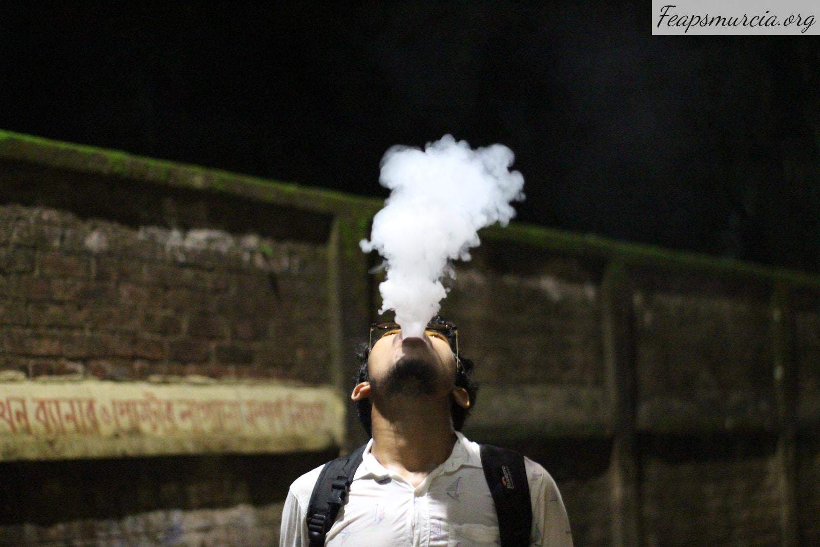 a man with a backpack is smoking a cigarette