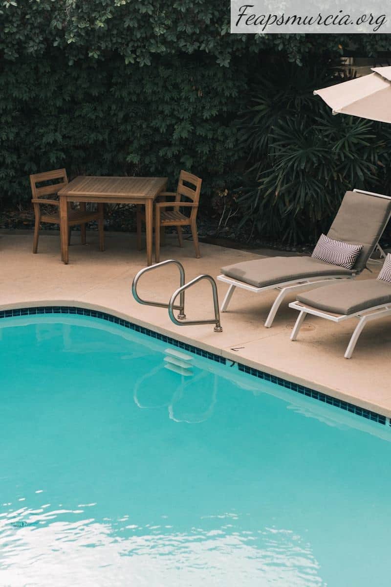 two gray sunbathing loungers beside pool